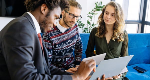 A diverse group of young professionals engaged in a business meeting inside a modern office.
